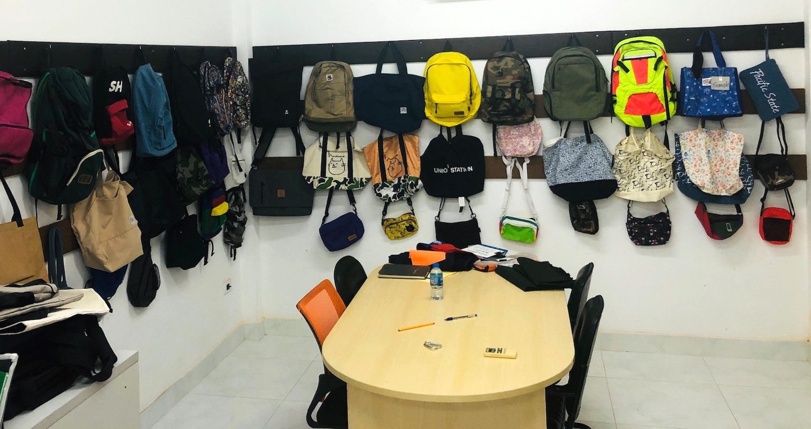 Backpacks, tote bags and shoulder bags on the sample room wall